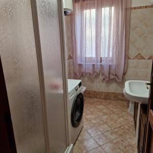 La salle de bains est pourvue d'un lave-linge et d'un lavabo. dans l'établissement Appartamento casa vostra, à Bosa
