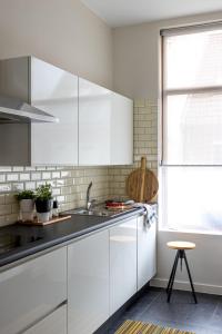 a white kitchen with a sink and a window at 3 Queens in Bruges +26 photos