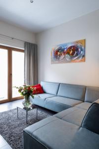 ein Wohnzimmer mit einem blauen Sofa und einem Gemälde in der Unterkunft 3 Queens in Brügge