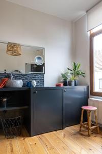 eine Küche mit einer schwarzen Theke und einem Stuhl in der Unterkunft 3 Queens in Brügge