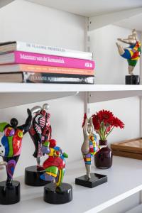 une étagère avec des figurines sur elle et des livres dans l'établissement 3 Queens, à Bruges