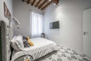- une chambre avec un lit et une télévision murale dans l'établissement Emilia Suite Palace, à Modène