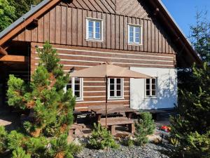 a house with a picnic table and an umbrella at BP Chata Ostružná in Ostružná