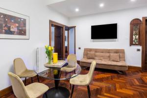 uma sala de estar com um sofá e uma mesa de vidro em DEZA cozy place Nazionale em Roma
