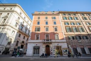 dwa wysokie budynki obok siebie na ulicy w obiekcie DEZA cozy place Nazionale w Rzymie