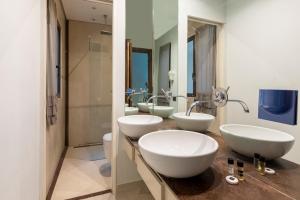 a bathroom with three sinks and a shower at DEZA cozy place Nazionale in Rome