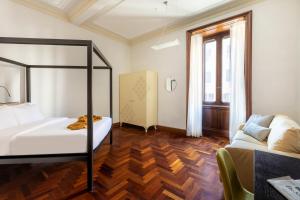 a bedroom with a bed and a couch in it at DEZA cozy place Nazionale in Rome