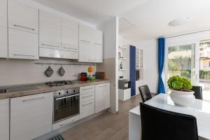 a kitchen with white cabinets and a table with chairs at Casa Pineta in Follonica