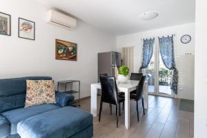 a living room with a blue couch and a table at Casa Pineta in Follonica