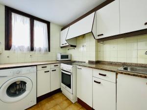 サロウにあるCOSTA DAURADA APARTAMENTS - Formentor 736のキッチン(白いキャビネット、洗濯機、乾燥機付)