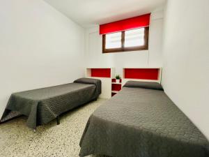 a room with two beds and a window in it at COSTA DAURADA APARTAMENTS - Formentor 736 in Salou