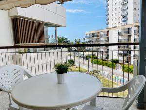 - Balcón con mesa blanca y sillas en COSTA DAURADA APARTAMENTS - Formentor 736, en Salou