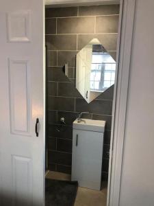 a small bathroom with a sink and a staircase at Loughor Annnex, Llangennech , Wales 