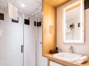 uma casa de banho com um lavatório e um chuveiro em Mercure Tours Sud em Joué-lés-Tours