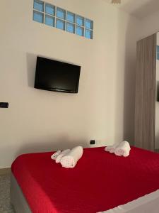 a bedroom with a red bed with two towels at Casa Levante in Augusta