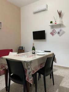 a dining room table with a bottle of wine on it at Casa Levante in Augusta