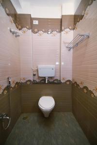 a bathroom with a white toilet and a shower at GV Resort in Yercaud