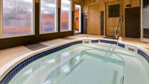 Best Western Plus Peace River Hotel & Suites في Peace River: مسبح كبير في حمام شبابيك