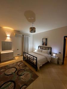 a bedroom with a large bed and a rug at New Cairo Modern Apartment in Cairo