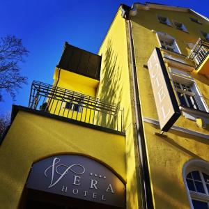 un edificio amarillo con un cartel para un hotel en Hotel Vera en Jáchymov