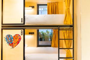 2 łóżka piętrowe w pokoju z oknem w obiekcie Petit Hostel Palacio Real w Madrycie