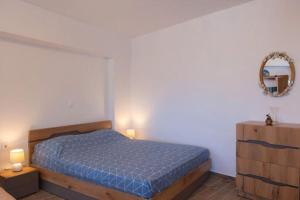 a bedroom with a blue bed and a mirror at Kety’s house in Exámbela