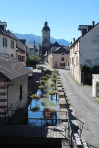 an empty street with a canal of water between buildings at GITE DU MOULIN in Arudy