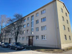 un gran edificio con coches estacionados frente a él en Cozy apartment near TalTech and Elamus SPA en Tallin