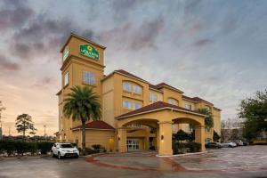 a hotel with a clock tower in a parking lot at La Quinta by Wyndham Houston IAH Bush Intl Airport E in Humble