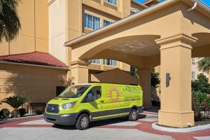 a yellow van parked in front of a building at La Quinta by Wyndham Houston IAH Bush Intl Airport E in Humble