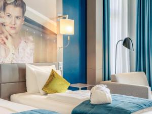 a room with a bed and a portrait of a woman at Mercure Berlin Wittenbergplatz in Berlin