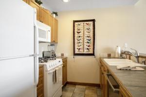 una cucina con un frigorifero bianco e un lavello di 224 Chapel Square condo ad Avon