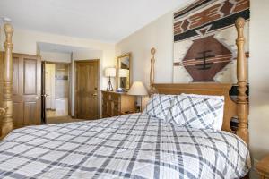 una camera da letto con un letto con un piumone blu e bianco di 224 Chapel Square condo ad Avon