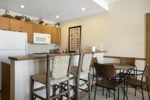 una cucina con bar e tavolo con sedie di 224 Chapel Square condo ad Avon