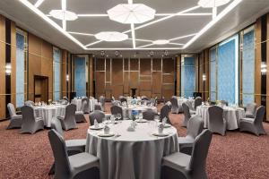 una sala conferenze con tavoli, sedie e lampadari a braccio di Wyndham Garden Baku a Baku
