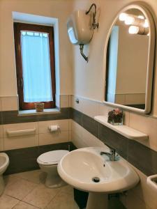 bagno con lavandino, servizi igienici e specchio di Appartamento i Gelsi a Praia a Mare