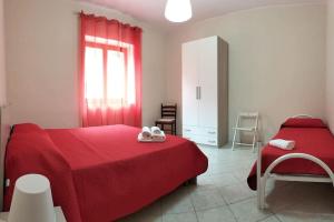 una camera con letto rosso e sedia di Appartamento i Gelsi a Praia a Mare