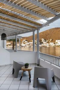 a patio with a table and chairs on a balcony at Cactus Suites Kythnos in Mérikhas