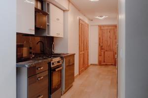 a kitchen with white cabinets and a stove top oven at Willa Cicha Basen Grota Solna Sauna in Rabka-Zdrój