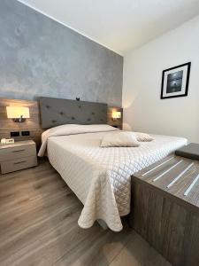 a bedroom with a large bed with white sheets at Hotel Regina in Grado