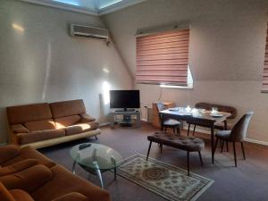 İndian hostel في باكو: غرفة معيشة مع أريكة وطاولة