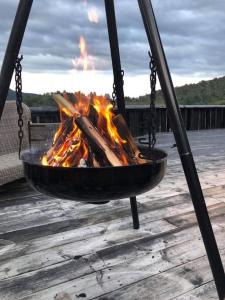 a fire pit with a bonfire in it on a deck at Nydelig hytte på Kvamskogen, nær Hardangerfjorden in Kvam