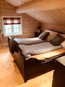 1 dormitorio con 1 cama en una cabaña de madera en Nydelig hytte på Kvamskogen, nær Hardangerfjorden en Kvam
