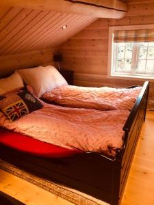 a bedroom with a bed in a log cabin at Nydelig hytte på Kvamskogen, nær Hardangerfjorden in Kvam