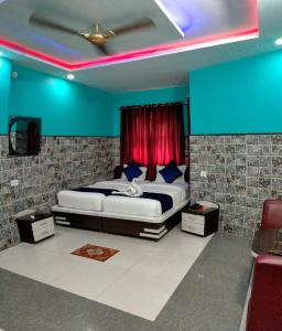 a bedroom with a bed with blue and red lighting at Hotel Bachchan Palace in Varanasi