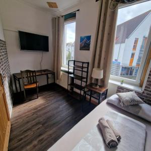 a bedroom with a bed and a desk and a television at VICTORY GuestHouse - Handwerker Pension in Bielefeld