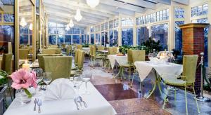 um restaurante com mesas e cadeiras brancas e janelas em Hotel im. Jana Pawła II em Breslávia