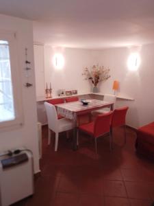 a dining room with a table and red chairs at In Vacanza a Gaeta - MariNella in Gaeta +25 photos
