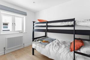 a bedroom with two bunk beds and a window at The Pink House, Budleigh Salterton in Budleigh Salterton