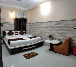 1 dormitorio con 1 cama grande y 1 silla en Hotel Bachchan Palace, en Varanasi